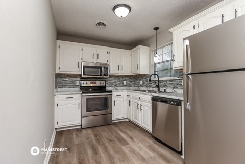a kitchen with white cabinets and stainless steel appliances
