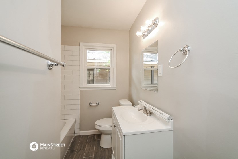 a bathroom with a toilet and a sink and a mirror