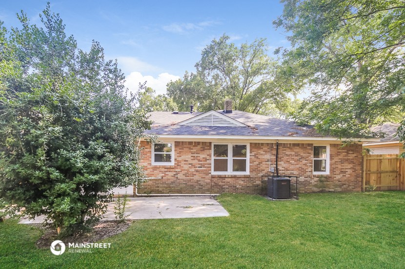 a small brick house with a yard and a tree