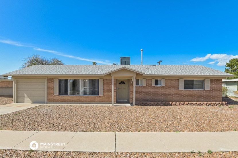 a small brick house with a blue sky in the background