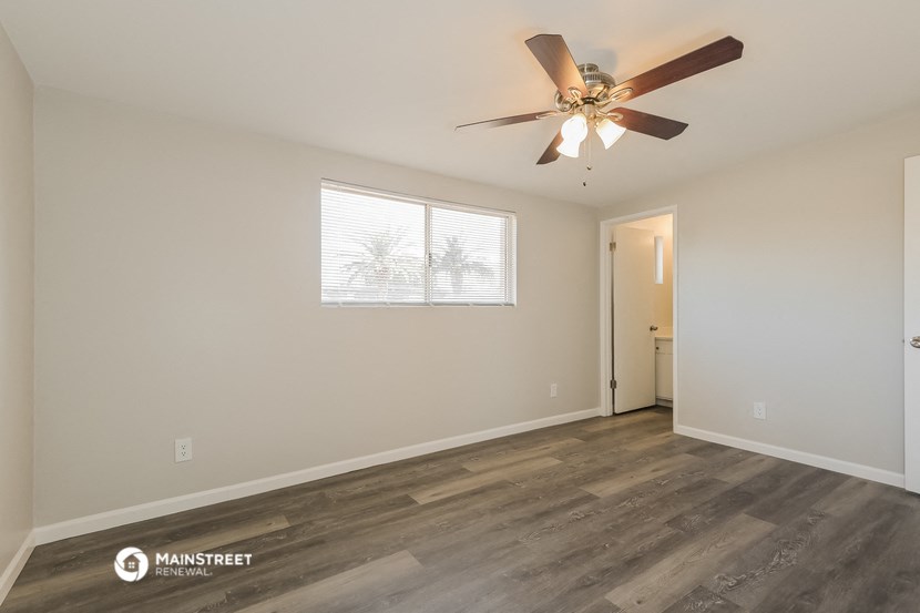 the living room of an apartment with a ceiling fan