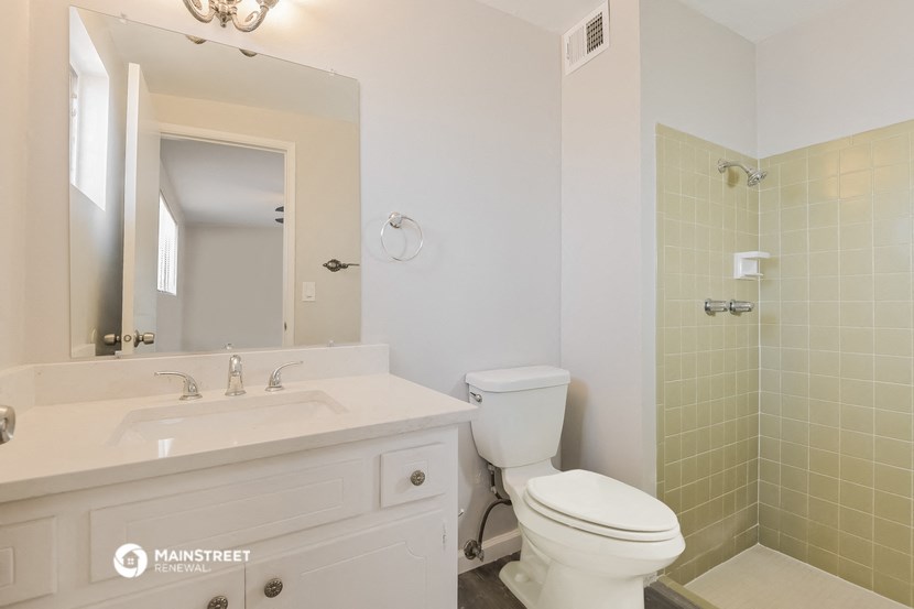 a bathroom with a toilet and a sink and a mirror