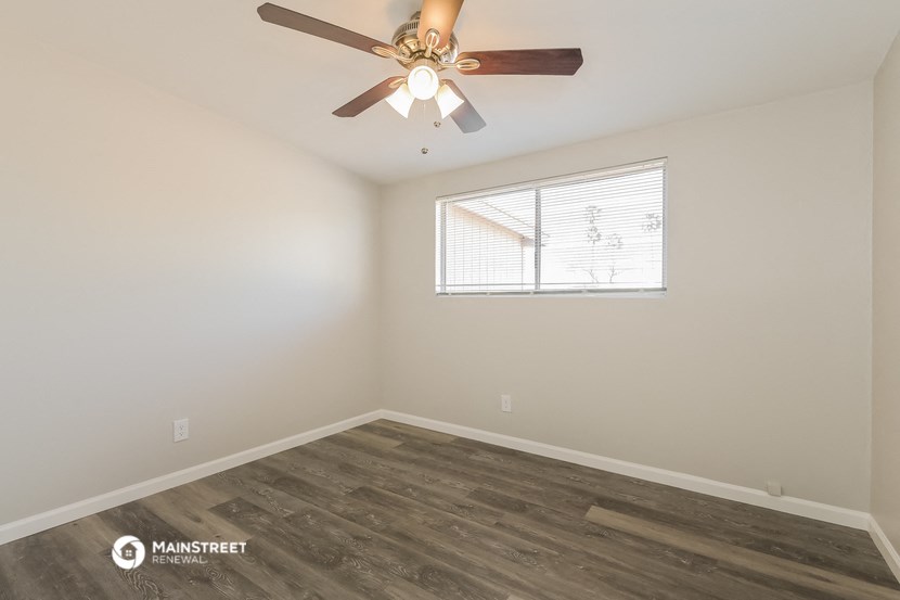 the bedroom has a ceiling fan and a window