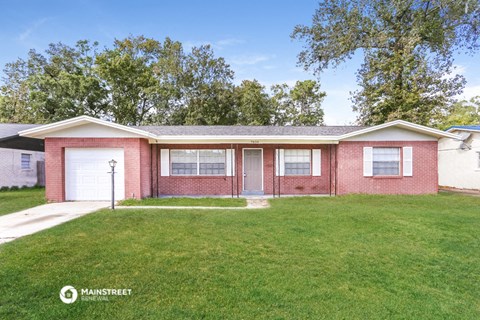 a brick house with a lawn and a white garage door