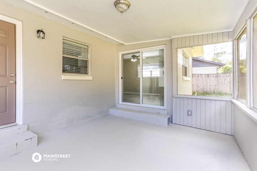 an empty porch with a door to a house