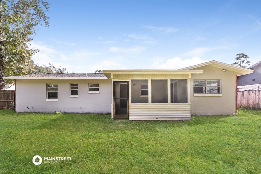 a small white house with a yard and a porch