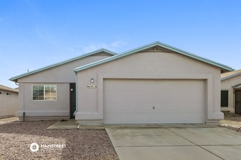 a beige house with a garage and a driveway