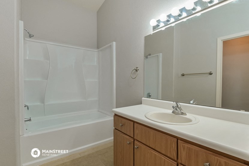 a bathroom with a sink and a shower and a mirror