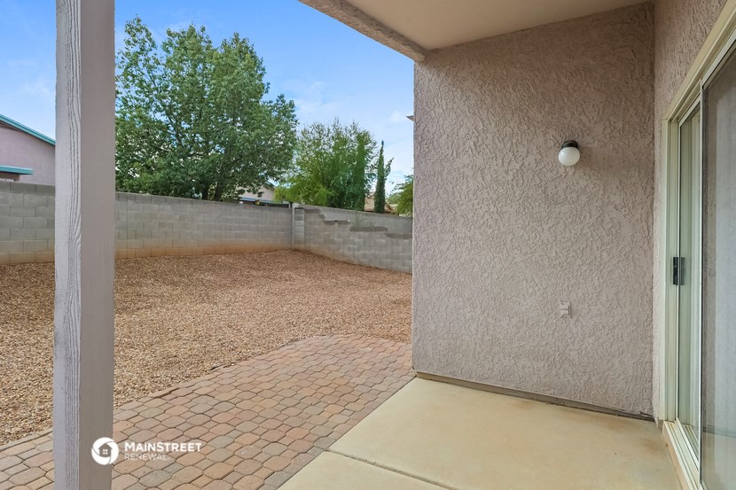 the backyard has a concrete wall and a sliding glass door