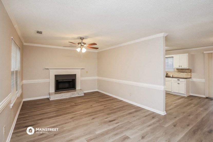 a living room with a fireplace and a ceiling fan