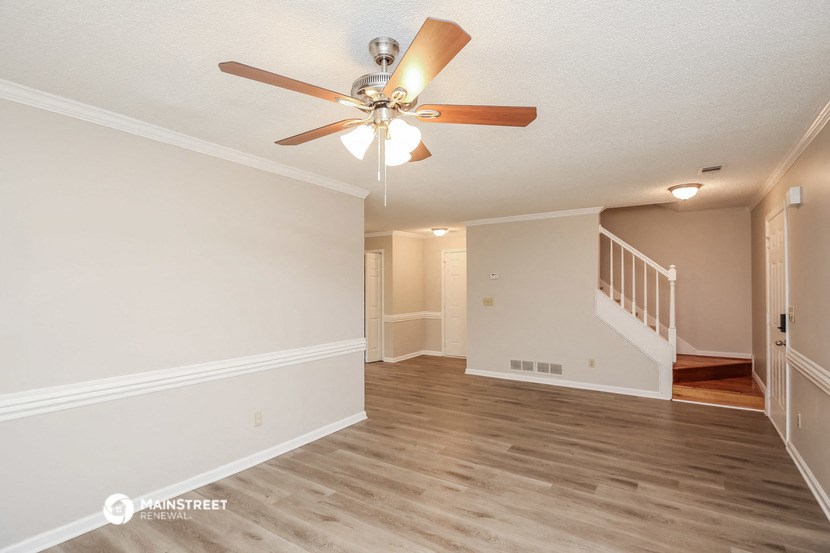 the spacious living room and dining room with a ceiling fan