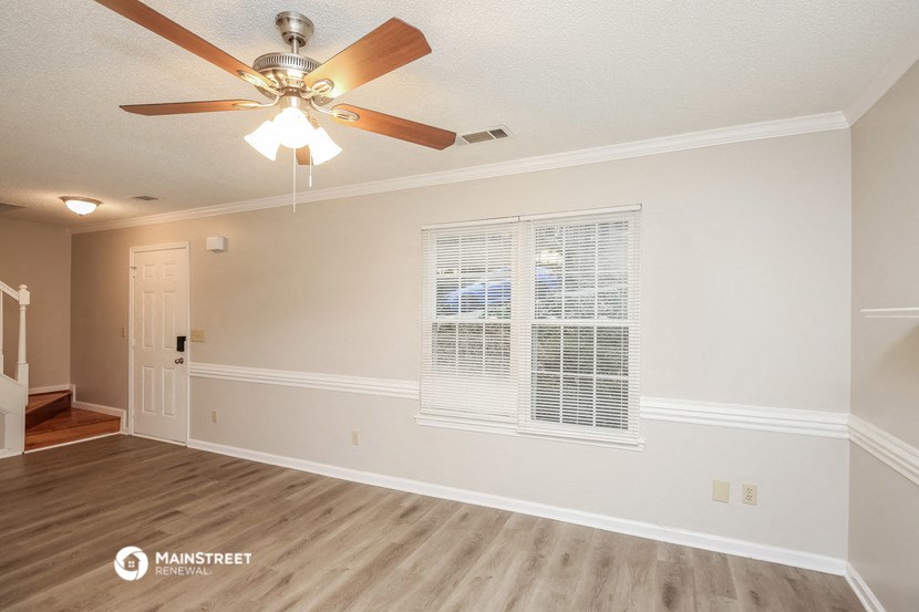 a living room with a ceiling fan and a window
