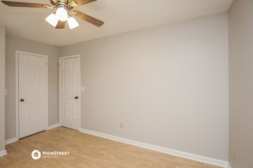 the living room of an empty house with a ceiling fan