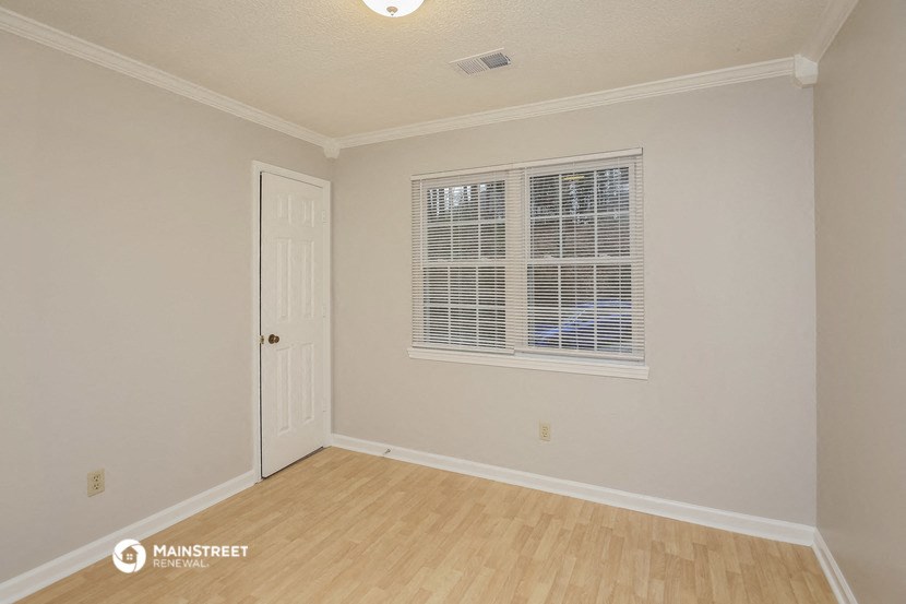 the living room of a house with a door and a window