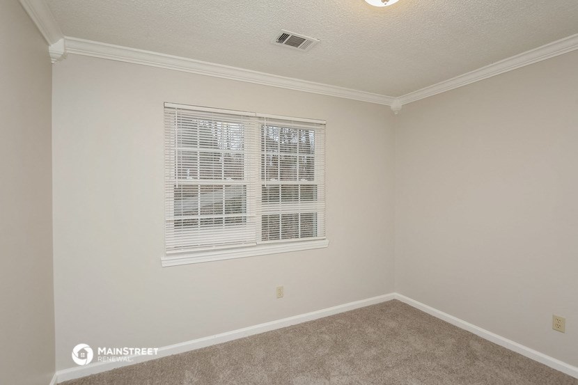 the living room of an empty home with a window