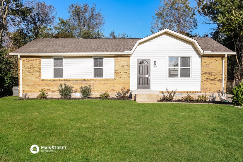 a small white house with a lawn in front of it