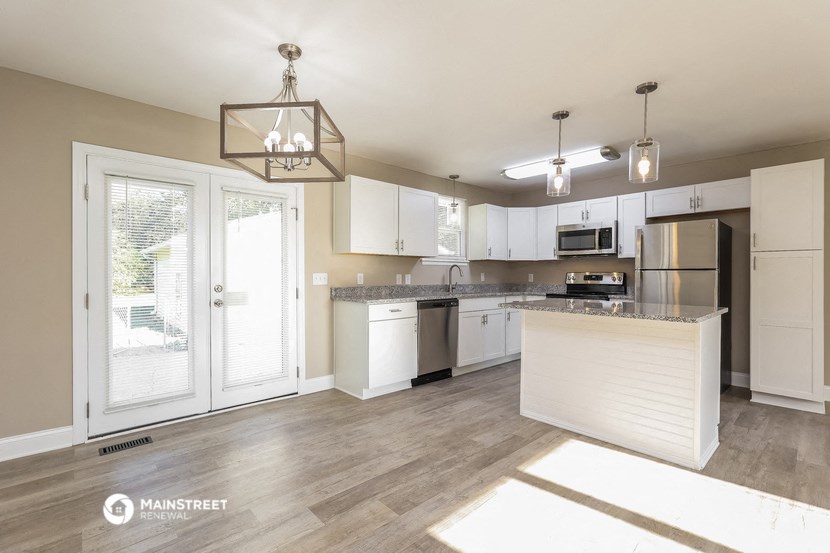 an open kitchen and living room with a door to a patio