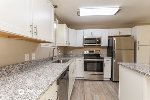 a kitchen with granite counter tops and stainless steel appliances