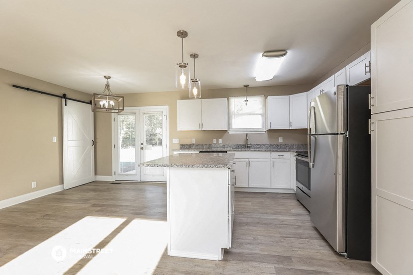 a large kitchen with white cabinets and stainless steel appliances