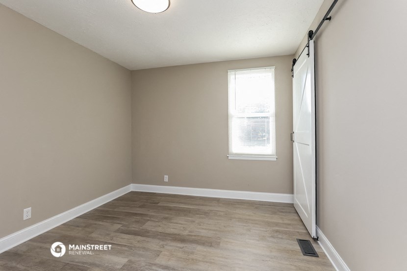 an empty room with a door and a window