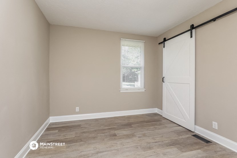 the interior of a bedroom with a door and a window