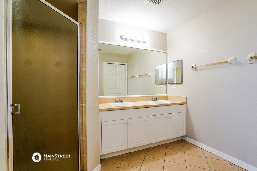 a bathroom with a sink and a shower and a mirror