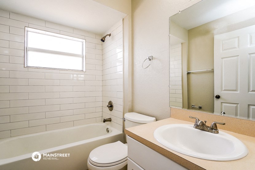a bathroom with a sink toilet and tub and a mirror