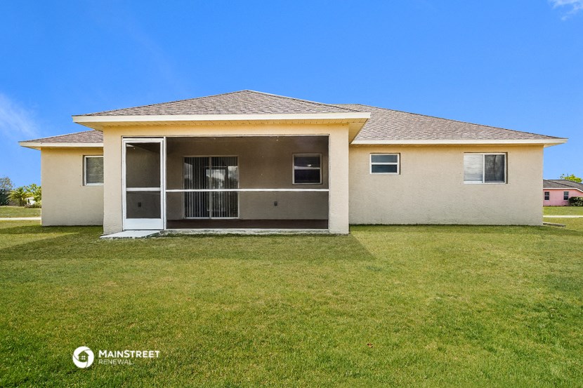 a beige house with a lawn and a door