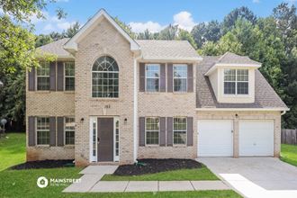 a brick house with a garage and a front yard