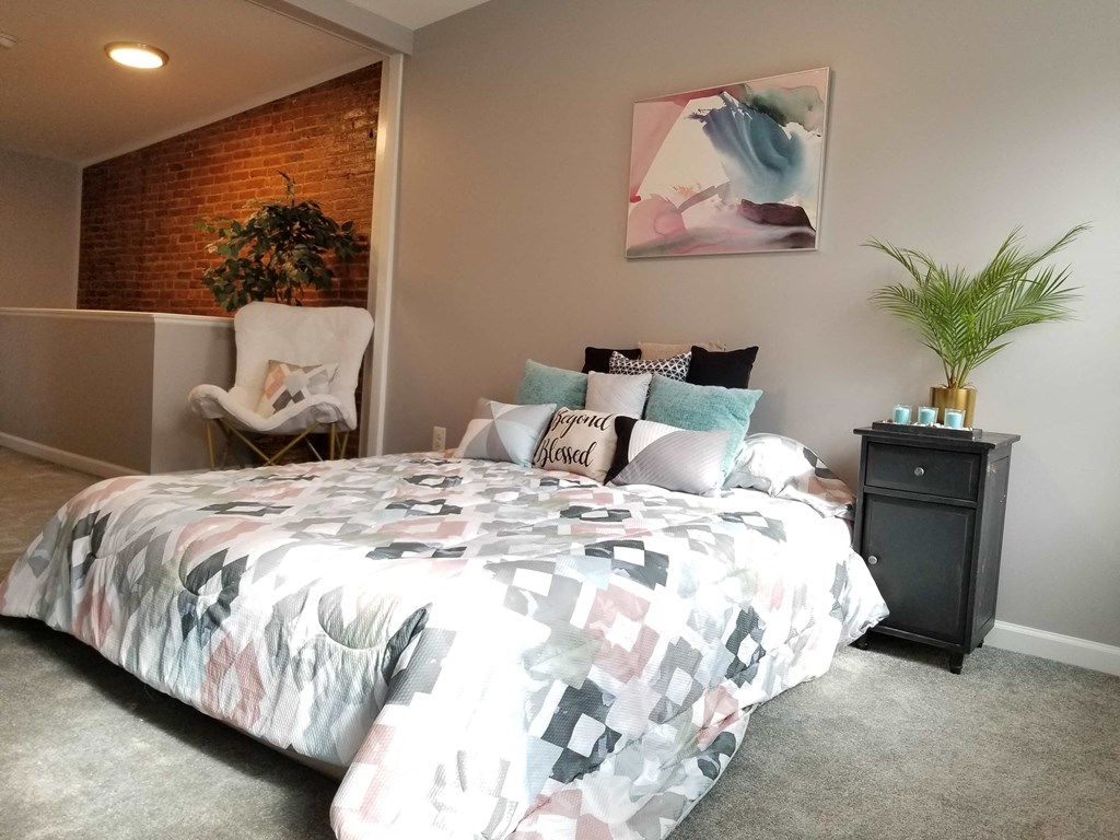 a bedroom with a bed and a plant