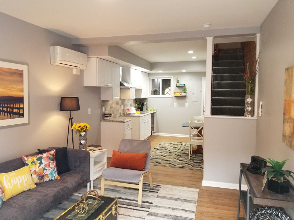 a small living room with a kitchen and a staircase