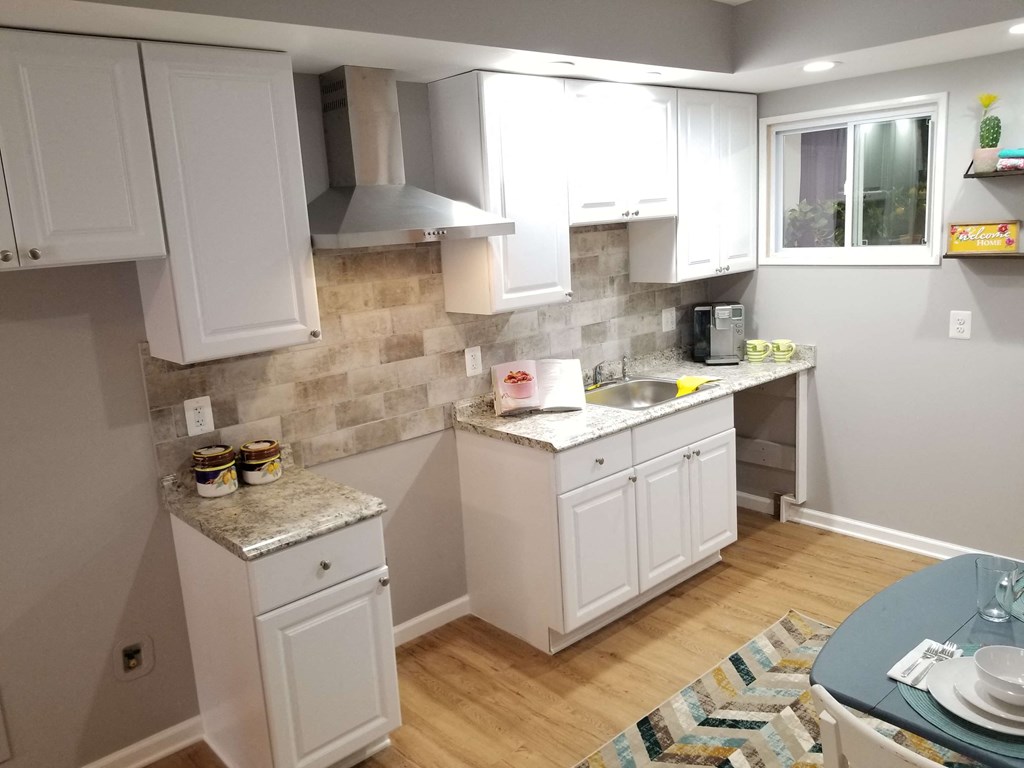 a remodeled kitchen with white cabinets and a sink