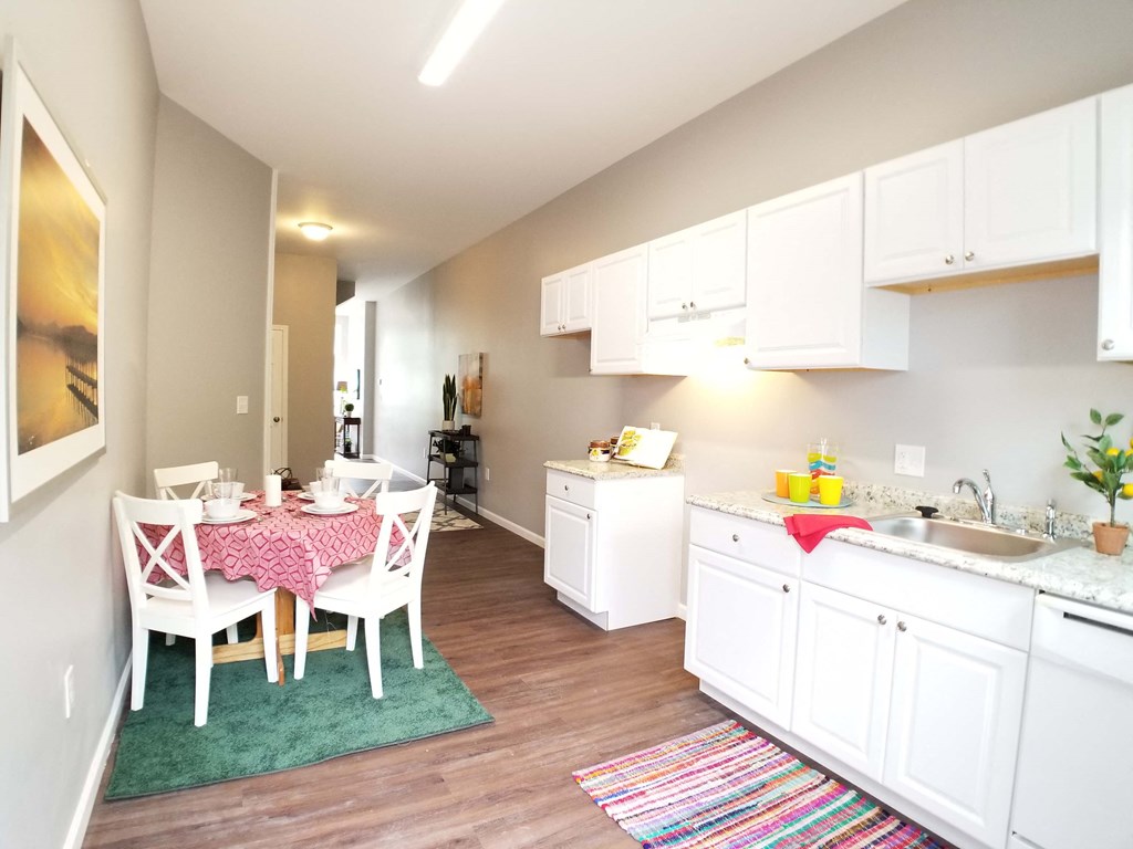 a kitchen and dining room with white cabinets and a table and chairs