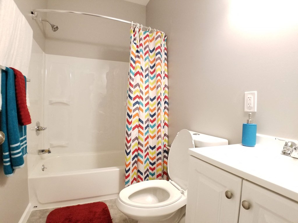 a bathroom with a toilet and a tub and a shower curtain