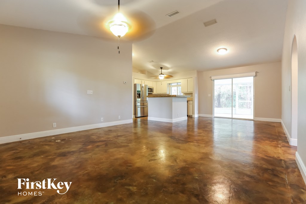 the living room and kitchen of an empty house