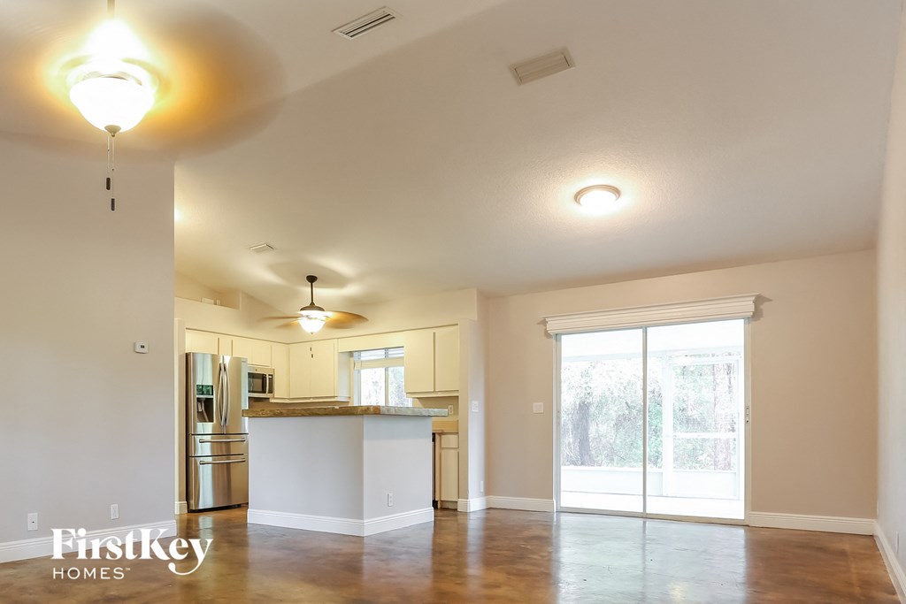 the kitchen and living room of an empty house