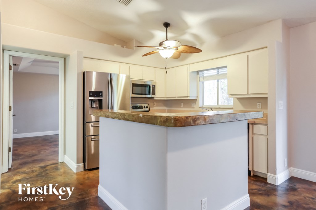 a kitchen with an island and a ceiling fan