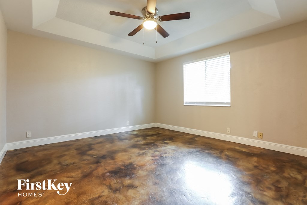an empty room with a ceiling fan and a window
