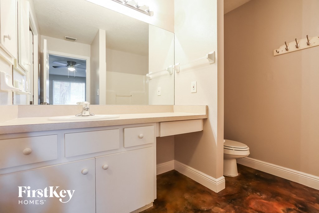 a bathroom with a large mirror and a sink and a toilet