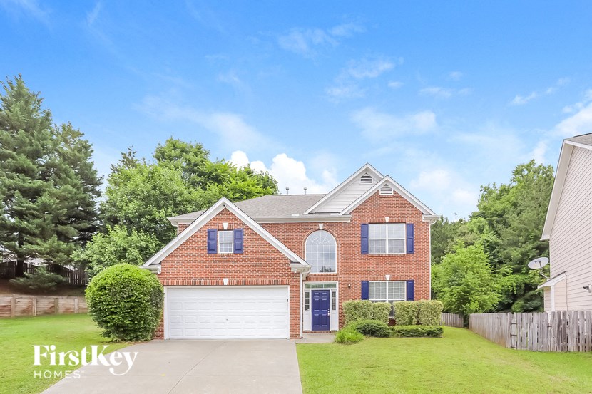 a brick house with a white garage door and a lawn