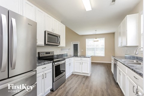 a kitchen with stainless steel appliances and white cabinets