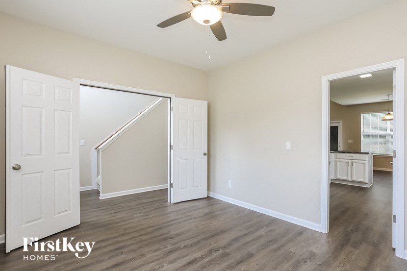 an empty living room with white walls and a ceiling fan
