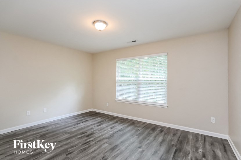 an empty living room with wood floors and a window