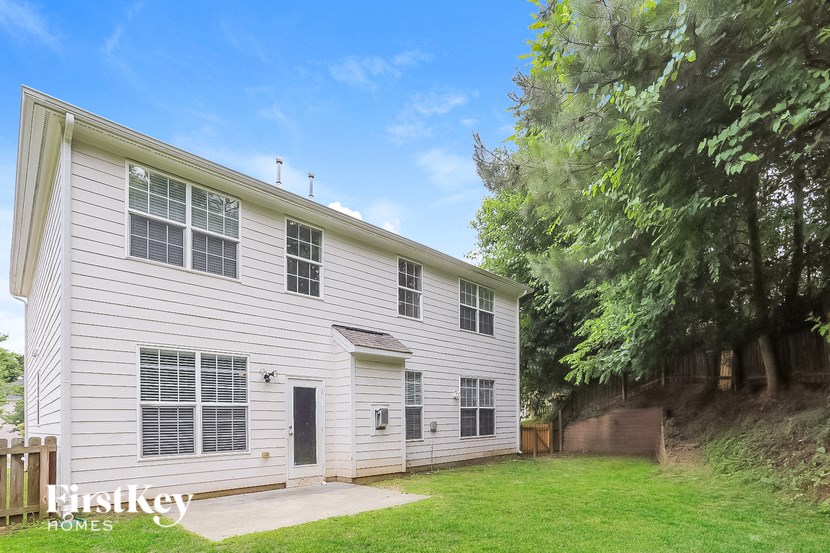 a white house with a lawn and trees