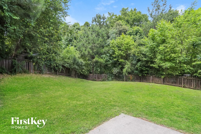 a backyard with a fenced in yard and a wood fence