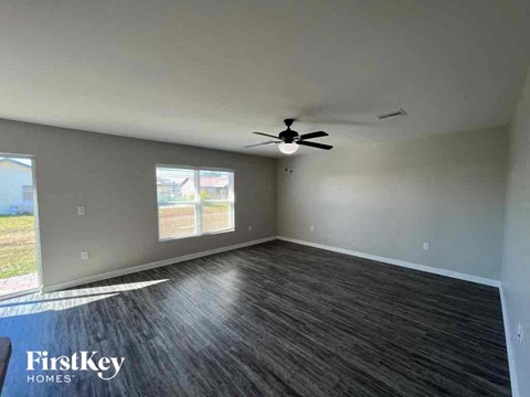 an empty living room with a ceiling fan