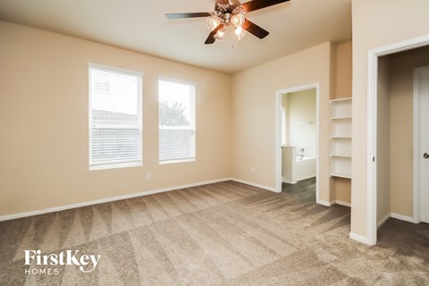 a living room with carpet and a ceiling fan
