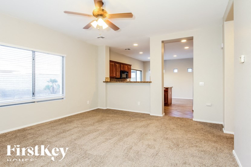 A spacious room with a ceiling fan and a carpeted floor.