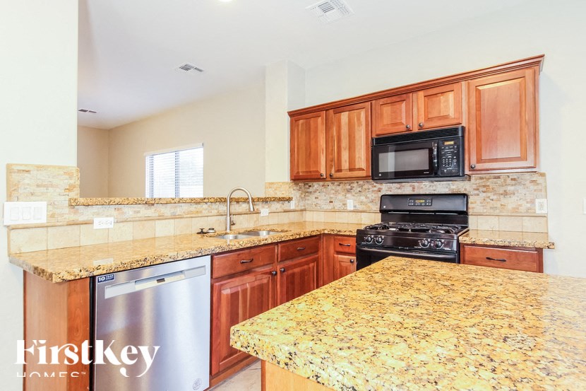 A kitchen with granite countertops and wooden cabinets.