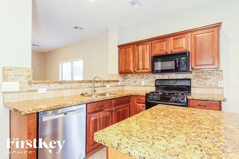 A kitchen with granite countertops and wooden cabinets.